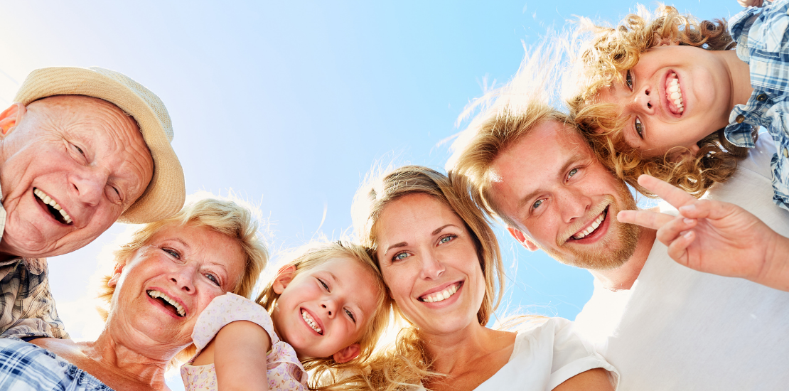 Altersvorsorge für Beamte 1 Drei Generationen einer Familie lachen gemeinsam in die Kamera – Symbol für sichere Altersvorsorge