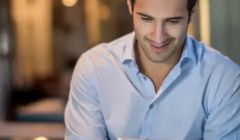 Junger Mann liest digitale Kundennews auf einem Tablet