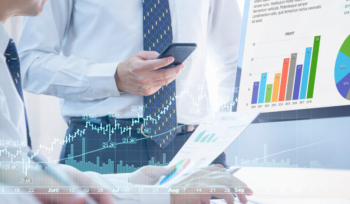 Zwei Personen arbeiten am Laptop mit Finanzcharts – Symbol für Fonds und ETF-Investitionen