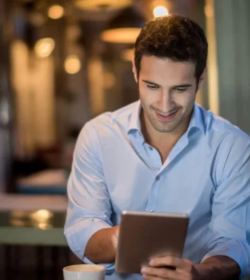 Junger Mann liest digitale Kundennews auf einem Tablet