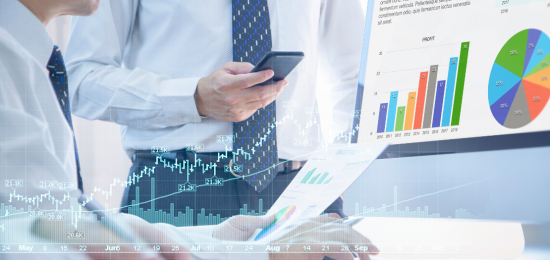 Zwei Personen arbeiten am Laptop mit Finanzcharts – Symbol für Fonds und ETF-Investitionen