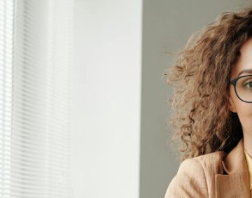 Junge Frau mit Brille blickt ruhig in die Kamera – symbolisch für Sicherheit, Vertrauen und gute Vorsorgeberatung.